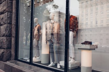 Mankenler, şehir merkezinde bir mağaza vitrin Sonbahar erkek kıyafet giymiş. Alışveriş ve satış kavramı. 