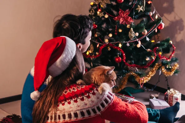 Pár Lásce Sedící Vedle Vánoční Stromek Santa Klobouk Objímání Mladí — Stock fotografie