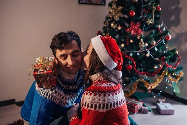 Paar Verliefd Zat Naast Een Kerstboom Kerstman Hoed Dragen Knuffelen — Stockfoto