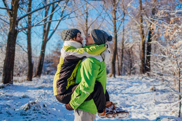 幸福的夫妇在爱在冬天的森林里散步和拥抱 抱着女朋友的男人年轻人玩得开心 — 图库照片
