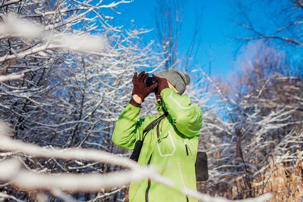年轻的摄影师用相机拍摄冬季森林的照片 年轻男子拍摄风景照片户外 — 图库照片
