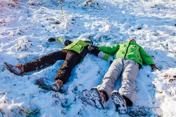 恋爱中的一对夫妇躺在雪地里 做着雪天使 快乐的人在冬天的森林里玩得很开心 季节性活动 — 图库照片