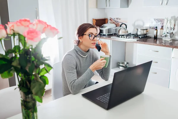 Woman Talking Phone Drinking Tea While Working Laptop Modern Kitchen — Stock Photo, Image