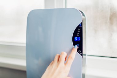 Kadın nem giderici dokunmatik panel tarafından ıslak penceresini kullanarak açar. Nem göstergesi dairede yüksek nem düzeyini gösterir. Hava kurutma makinesi