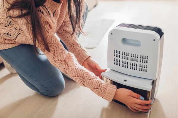 Woman changing water container of dehumidifier at home. Dampness in apartment. Modern air dryer technology — Stock Image Woman Changing Water Container Dehumidifier Home Dampness Apartment Modern Air Stock Picture