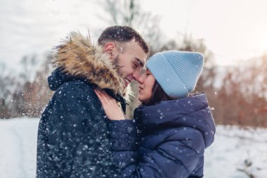 Çok güzel iki yürüyor ve kış ormanda sarılma sevgi dolu. Yağan kar altında açık havada eğleniyor insanlar