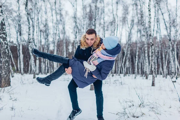 冬の森で手に彼のガール フレンドを運ぶ人 屋外楽しんで幸せな人 — ストック写真