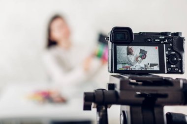 Genç kadın profesyonel güzellik vlogger veya blogger kayıt makyaj eğitimi kamera ve tripod evde kullanma
