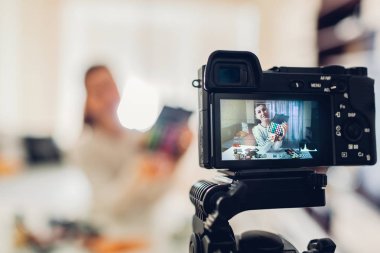 Genç kadın profesyonel güzellik vlogger veya blogger kayıt makyaj eğitimi kamera ve tripod evde kullanma