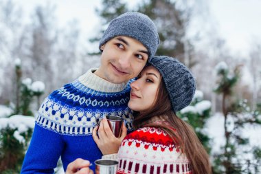 Genç çift çay içme ve kış ormanda sarılma. Mutlu insanlar açık havada tatil dönemlerinde rahatlatıcı. Sevgililer günü