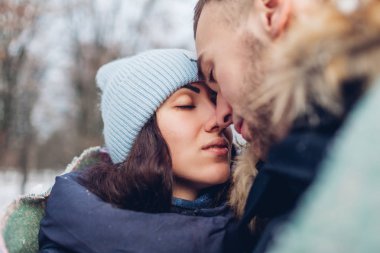 Güzel sevgi dolu çift sarılma ve diğerleri de kış ormanda gözlere bakmak. İnsanlar ısınma battaniye ile örtülü. Yakın çekim