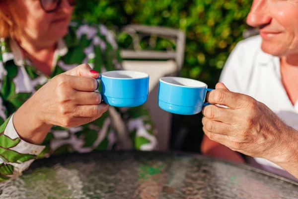 Senior couple drinking tea in hotel cafe. Happy people enjoying vacation. Close-up