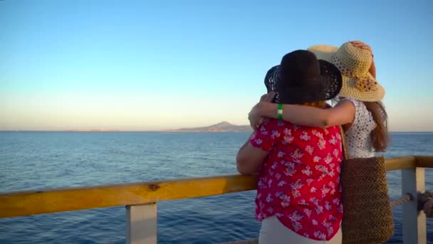 Mutter und erwachsene Tochter bewundern die Meereslandschaft und reden auf der Seebrücke. Blick auf die tiranische Insel in Ägypten. Sommerferien. 4k