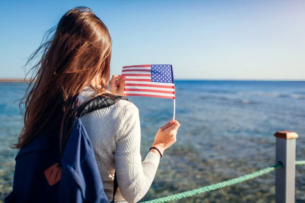 年轻的女游客欣赏红海的风景 在码头上举着乌萨旗 旅行理念 美国独立日 — 图库照片