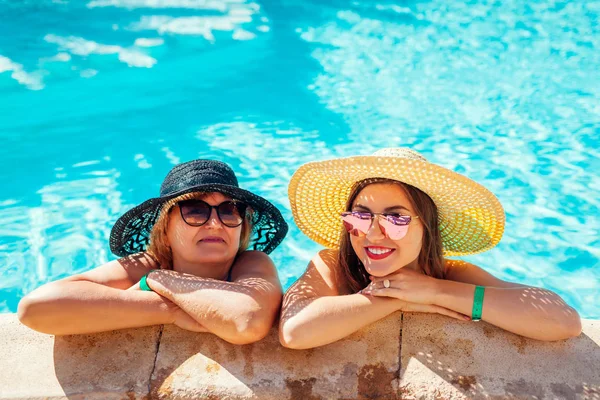 Üst düzey kadın yetişkin kızı otel yüzme havuzunda rahatlatıcı. Tatil zevk insanlar. Anneler günü