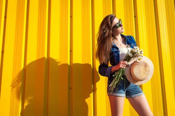 Gözlük ve sarı arka plana karşı çiçekli şapka giyen hippi kız portresi. Yaz kıyafeti. Moda. Uzay. — Stok fotoğraf