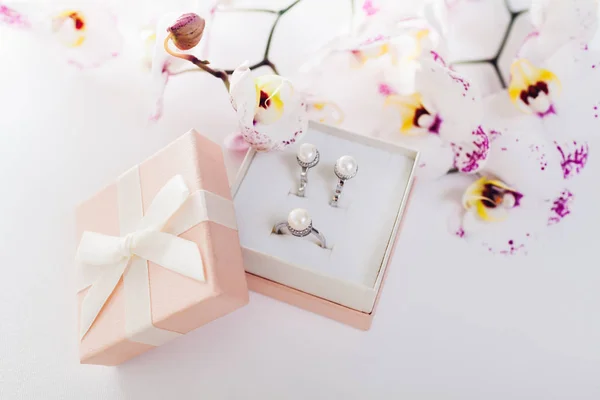 Set di anelli e orecchini in argento con perle nella confezione regalo con orchidea. Regalo per la festa della donna — Foto Stock