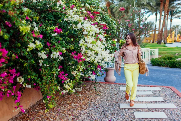 Retrato de una mujer joven y elegante caminando por flores tropicales en Egipto. Vacaciones de verano — Foto de Stock