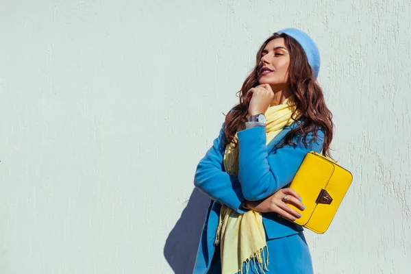 Młoda kobieta, trzymając Stylowa torebka i sobie modny niebieski płaszcz. Wiosna, kobiece ubrania i akcesoria. Mody — Zdjęcie stockowe