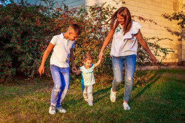 Mutlu aile harcama zaman açık havada Park'ta yürüyordunuz. Anne ve oğlu küçük yürümeye başlayan çocuk kız. Anneler günü