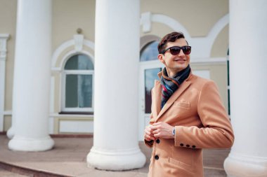 Şehirde yürüyüş şık delikanlı. Klasik giysi ve aksesuarları giyen yakışıklı adam. Sokak moda