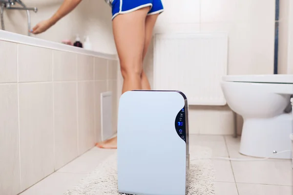 Dehumidifier met aanrakingspaneel, vochtigheid indicator, UV-lamp, lucht-ionisator, watercontainer werken in badkamer. Luchtdroger — Stockfoto