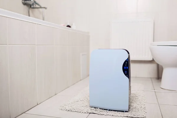 Осушитель с сенсорной панелью, индикатор влажности, ультрафиолетовая лампа, ионизатор воздуха, емкость для воды работает в ванной комнате. Фен — стоковое фото
