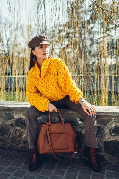 Young woman holding stylish handbag and wearing yellow sweater. Spring female clothes and accessories. Fashion — Stock Photo, Image