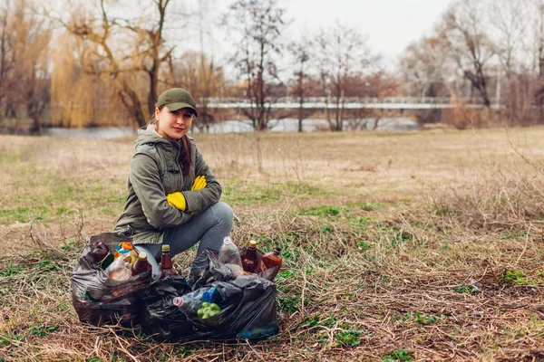 Vrouw vrijwilliger opgeruimd de prullenmand in park. Mensen pakte vuilnis en weergegeven: resultaat met volle tassen. Ecologie — Stockfoto