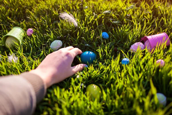 Happy Easter. Easter eggs hidden in spring grass. Woman holding egg