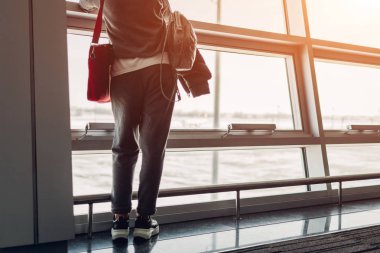 Havaalanı salonunda uçakta yatılı bekleyen pencere bakarak kadın Gezgin