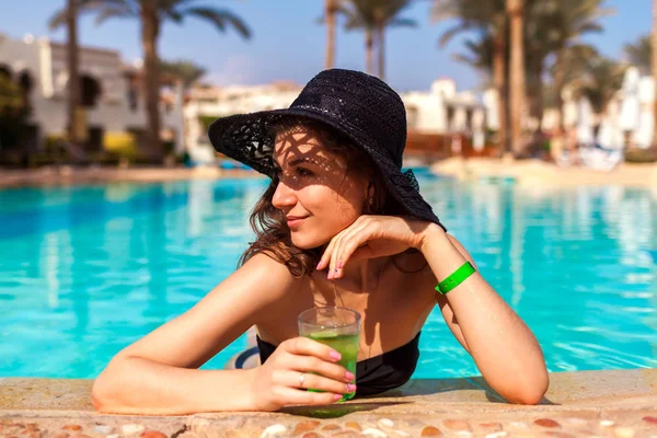 Woman holds a cocktail in hotel swimming pool. Summer vacation. All inclusive — Stock Photo, Image