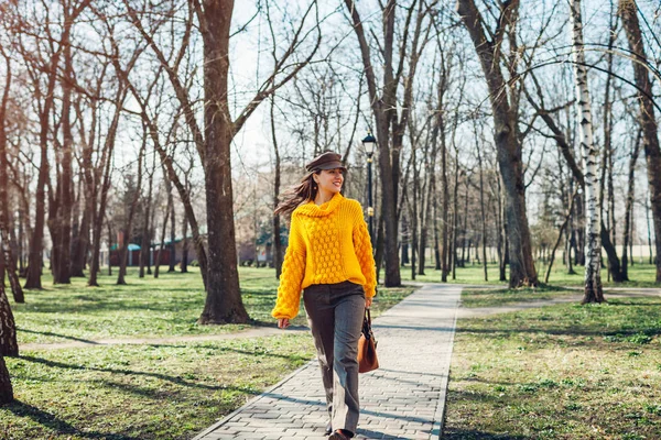 Молодая женщина держит стильную сумочку и носит желтый свитер. Весной женская одежда и аксессуары. Мода — стоковое фото