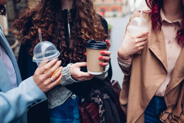 屋外で飲み物を飲む3人の女性の友人。コーヒー、オレンジジュース、ティーカップをクリンキングする女性 — ストック写真