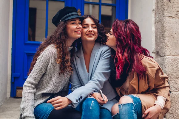 Молодые женщины обнимаются и смеются на городской улице. Лучшие друзья хорошо проводят время вместе — стоковое фото