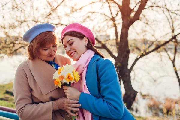 Filha dando sua mãe buquê de flores. Conceito de dia da mãe — Fotografia de Stock