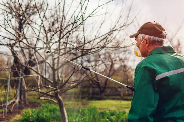 Дерево фермера с ручным опрыскивателем пестицидов против насекомых в весеннем саду. Сельское хозяйство и озеленение — стоковое фото