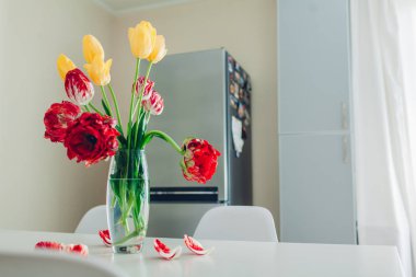 Modern mutfak tasarımı. Beyaz ve gümüş mutfak iç çiçeklerle süslenmiş. Rahat daire