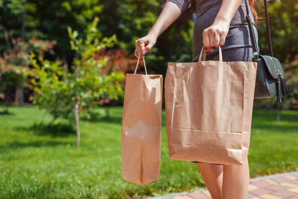 Mujer joven sosteniendo bolsas de papel de compras en el parque de verano y el uso de ropa de moda . — Foto de Stock