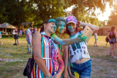 Myrhorod, Ukrayna - 16 Haziran 2019: Hint Holi renk festivaline boya attıktan sonra selfie çeken aile