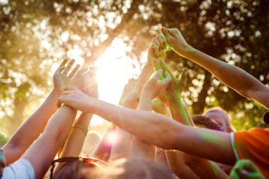 Hint Holi festivalinde boya atan bir grup genç. Ellerin yukarı yayılTın