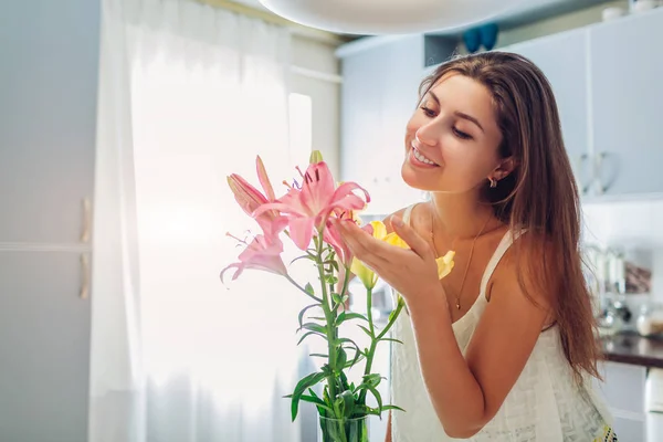 Kvinna lukta bukett av liljor. Hemmafru njuter av inredning och inredning av kök. Sweet Home — Stockfoto