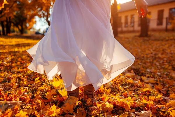 Mujer bailando en el bosque otoñal con hojas de arce amarillo y naranja. Señora vistiendo elegante falda blanca —  Fotos de Stock