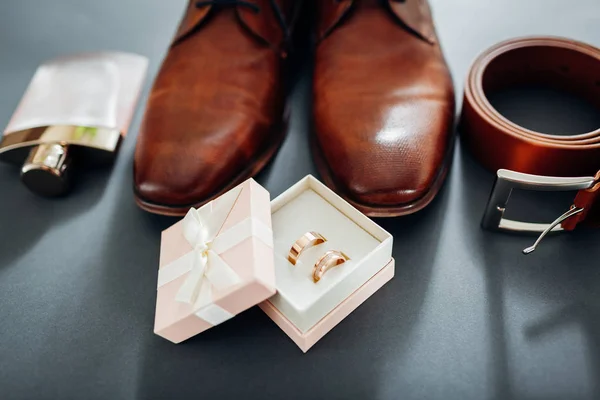 Bruidegom bruiloft dag accessoires. Bruin lederen schoenen, riem, parfum, gouden ringen. Mannelijke mode — Stockfoto