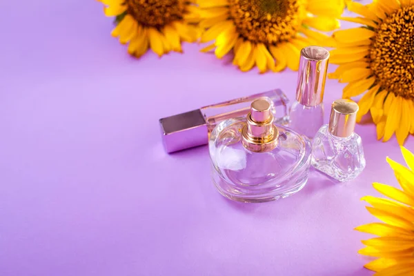 Bouteilles de parfum avec tournesols sur fond violet. Cosmétiques biologiques — Photo