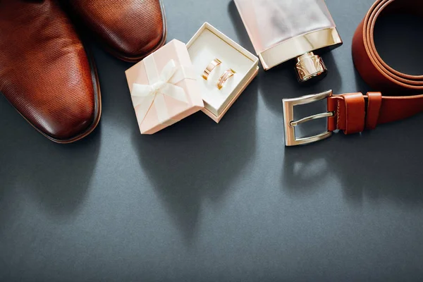 Bruidegom bruiloft dag accessoires. Bruin lederen schoenen, riem, parfum, gouden ringen. Mannelijke mode — Stockfoto