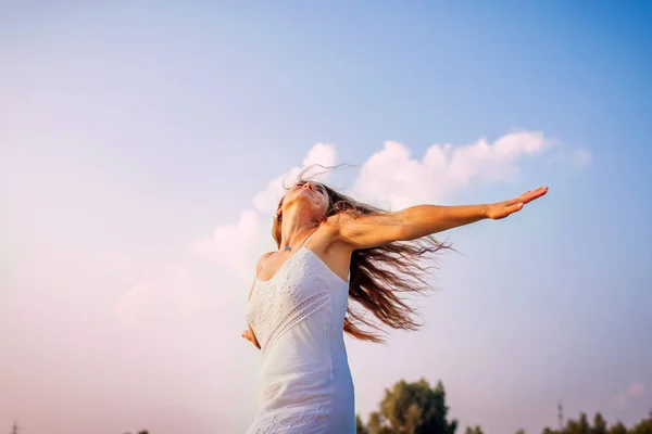 Fiatal nő érzés ingyenes, és boldog növelése karok és spinning a szabadban, naplementekor — Stock Fotó