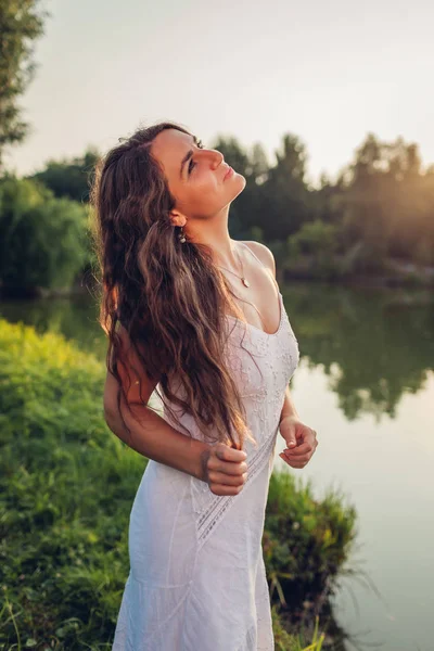 Mladá krásná žena, která se cítí svobodná a šťastná chůze v létě při západu slunce na obdivování krajiny — Stock fotografie