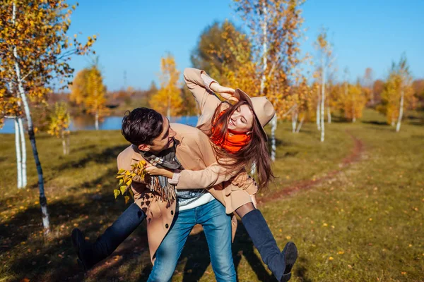 Giovani passeggiate di coppia nella foresta autunnale. Un uomo che regala la sua ragazza a cavallo. Persone che si divertono — Foto Stock