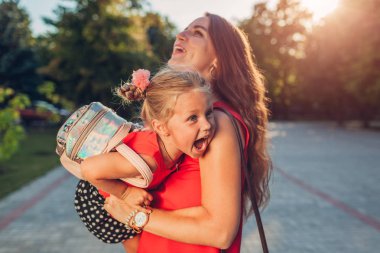 Mutlu anne sınıflar açık ilkokul ve gıdıklayan çocuk sonra kızı toplantı. Aile eğleniyor